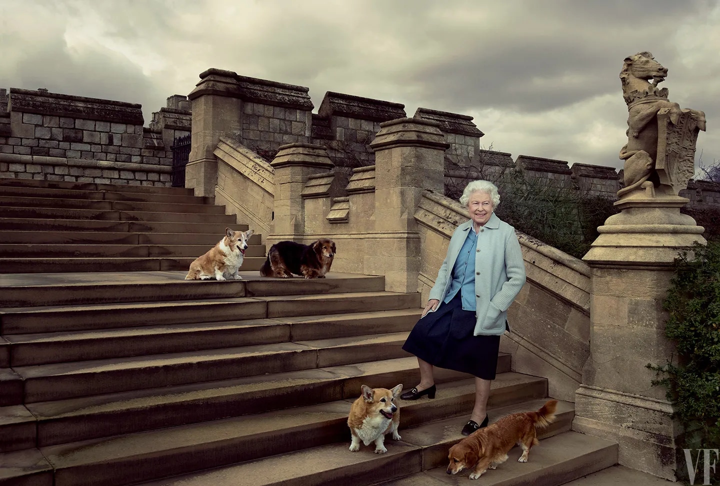 Königin Elizabeth II. auf den Stufen der Ostterrasse von Schloss Windsor mit Corgi Willow, Dorgi Vulcan, Corgi Holly und Dorgi Candy, im April 2016 - Foto: Annie Leibovitz